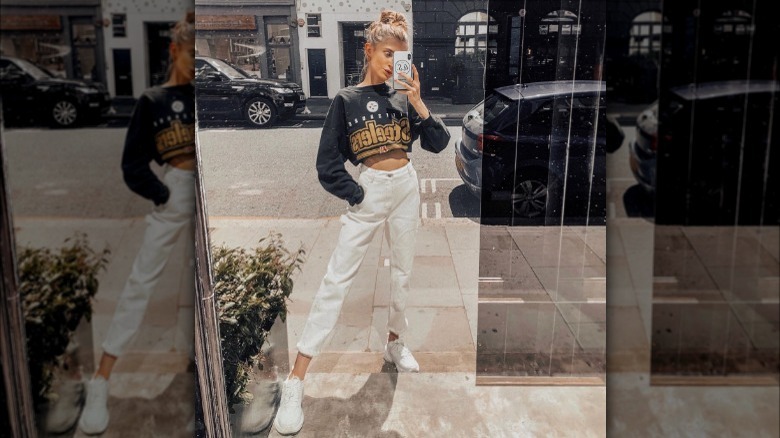 Woman wearing cropped sweater and jeans