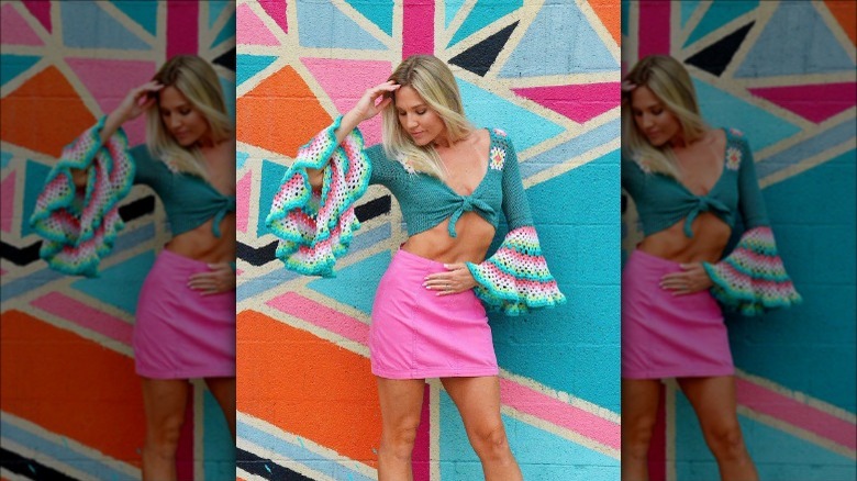 Individual in a short sweater with crocheted bell sleeves