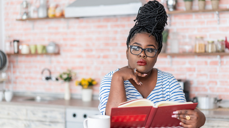 Serious woman pondering while reading 