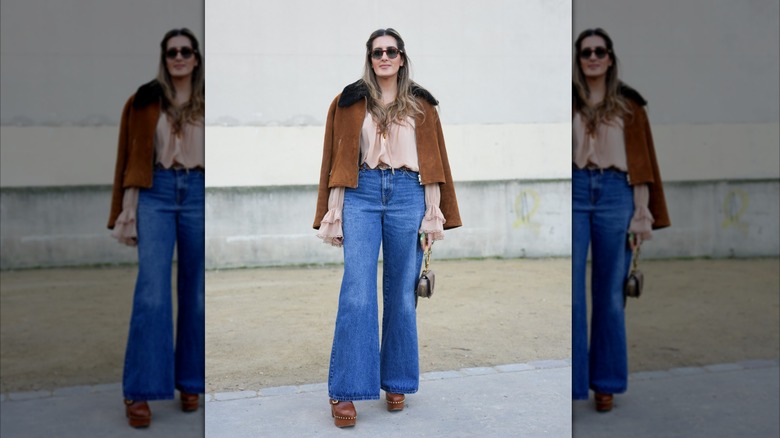Woman wearing a suede jacket and flared jeans