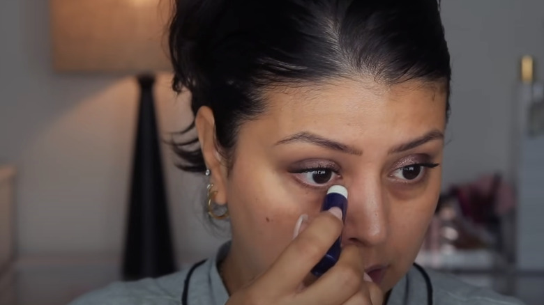 Woman applying under-eye Aquaphor 