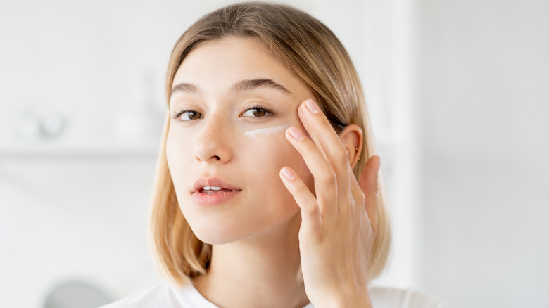Woman applying under-eye cream 