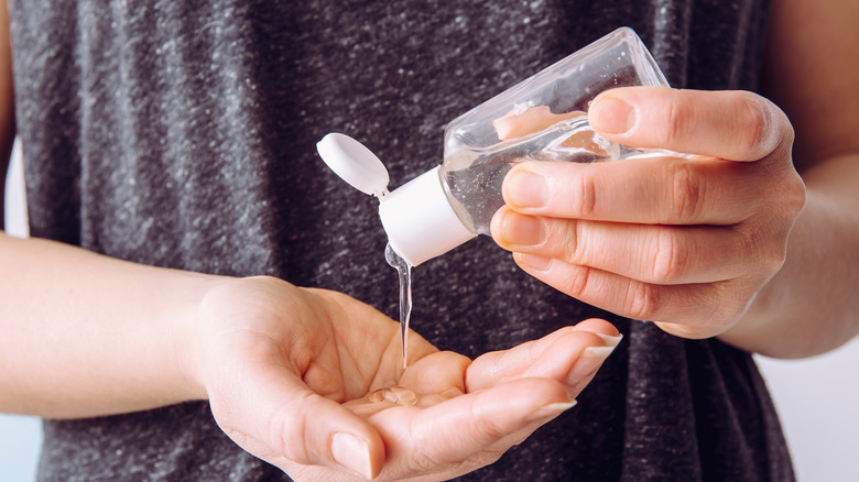 Woman applying sanitizer to hands