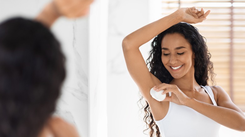 Woman applying deodorant