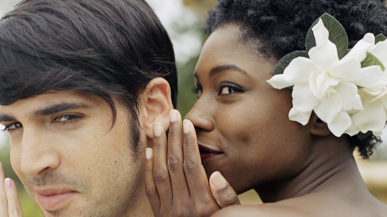 woman whispering to man