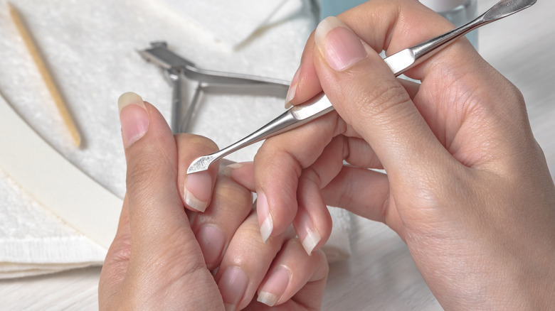 Woman pushing her cuticles