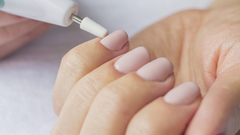 Woman using an electric nail file