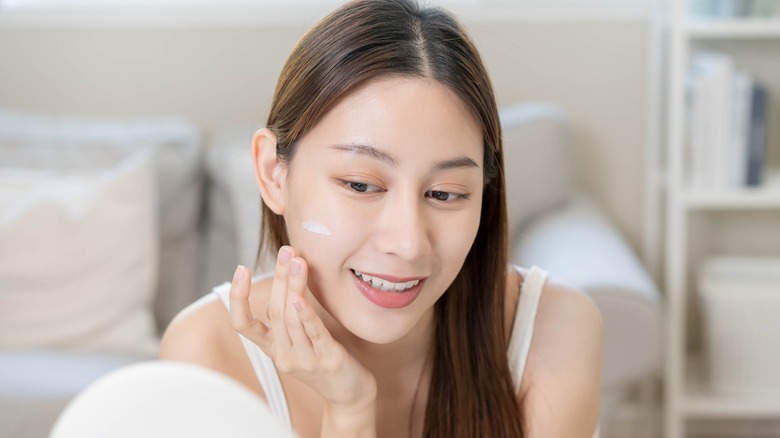 Woman putting on face cream