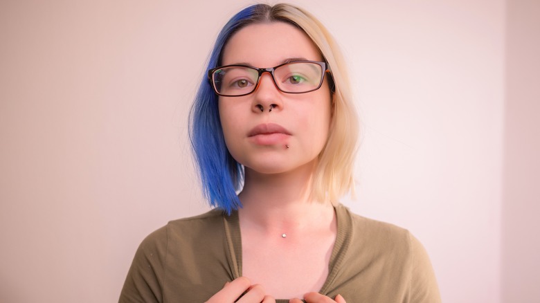 Woman showing dermal piercing on collarbone