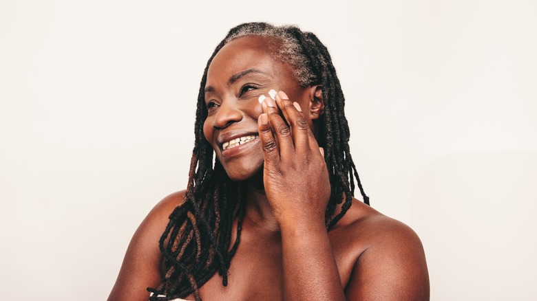 woman applying moisturizer to her skin