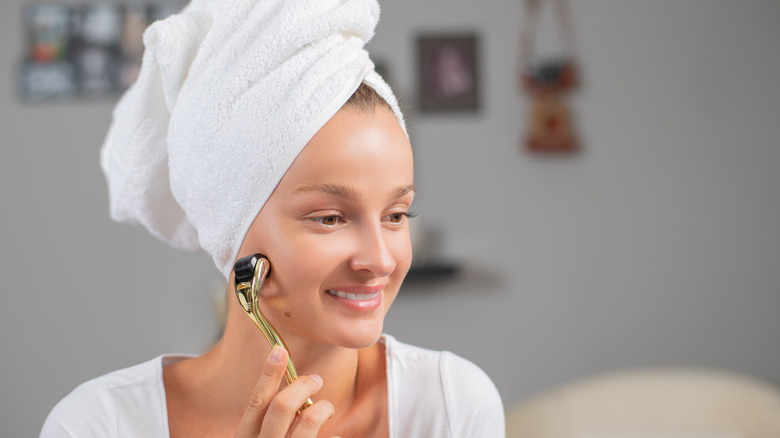 woman dermarolling her face at home