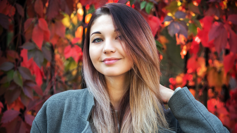 Woman in fall leaves with brassy hair