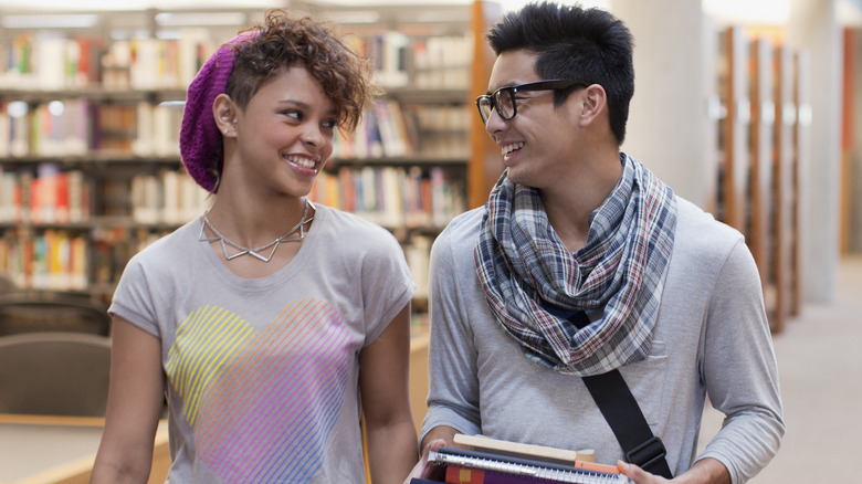 happy friends talking in a library