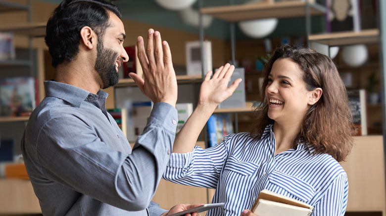 man and woman high-fiving
