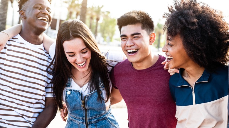four happy friends hugging