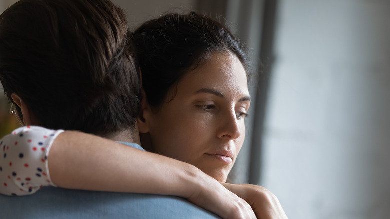 unhappy woman hugging a man