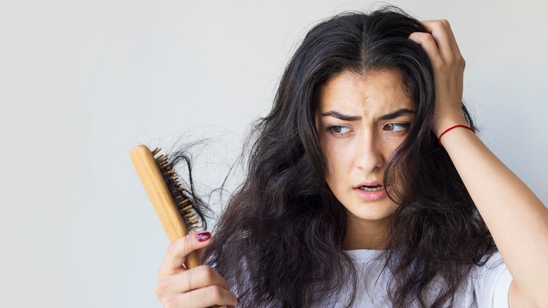 Girl looking at damaged hair.