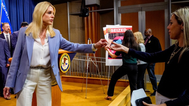 Pam Bondi wearing a blue blazer with a white shirt and pants