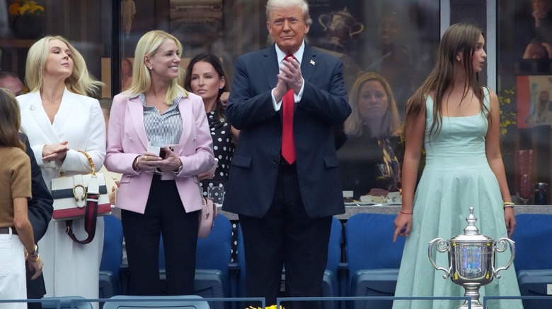 Pam Bondi wearing a pink suit jacket with black pants and a striped shirt