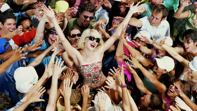 Woman center of attention in cheering crowd