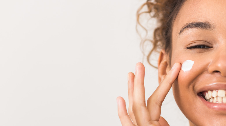 woman smiling with cream on cheek