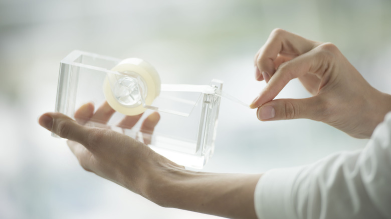 A person cutting tape