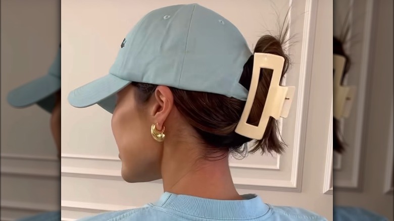 Woman wearing cap and claw clip 