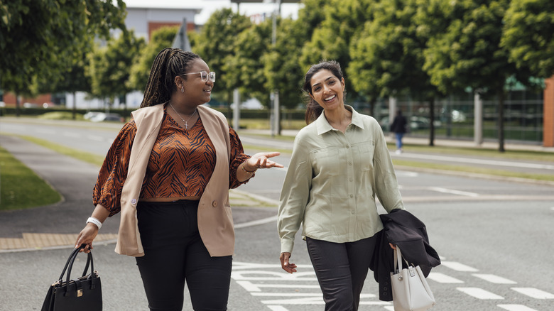 Two women walk into the workplace together