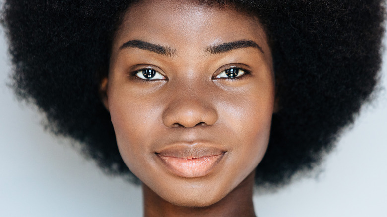 Smiling Black woman with afro and clean face
