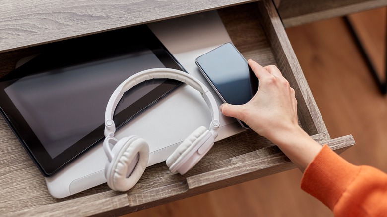 Woman's hand putting away electronic devices