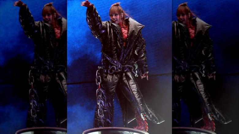 Lisa performing at Coachella in 2025 in an oversized black puffer coat.