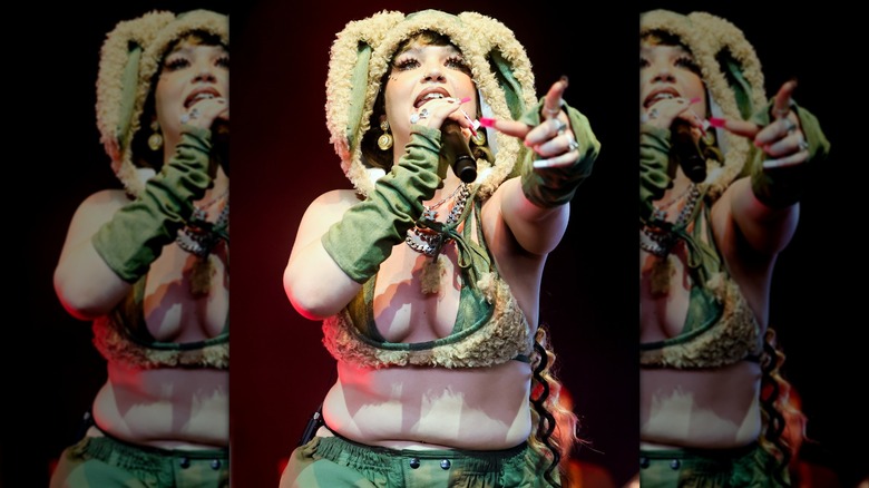 Lola Young on stage at Coachella 2025 in a fuzzy ensamble featuring a hood with ears.