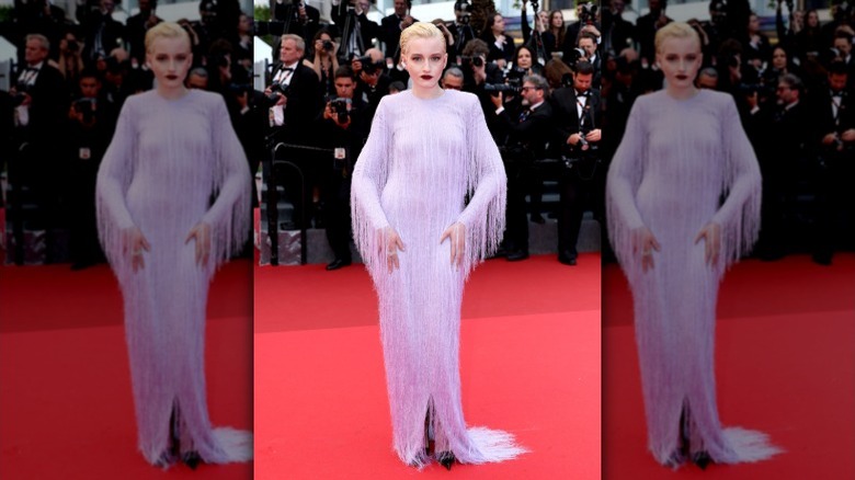 Julia Garner poses on the Cannes red carpet in a purple dress