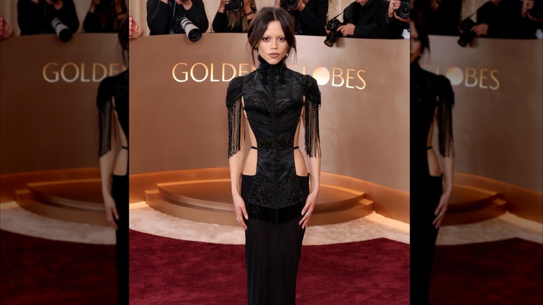 Jenna Ortega stands on the Golden Globes red carpet