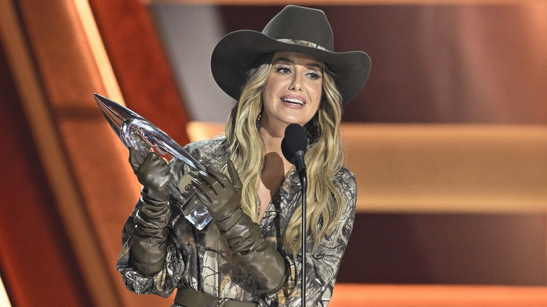 Lainey Wilson in a graphic jumpsuit and leather gloves