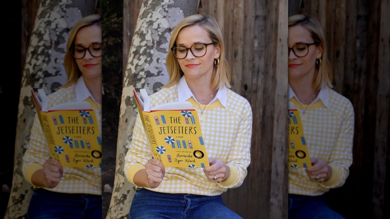 Reese Witherspoon in a yellow-and-white sweater reading "The Jetsetters" by Amanda Eyre Ward