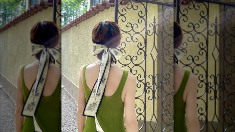 a woman wearing a skinny scarf in her hair