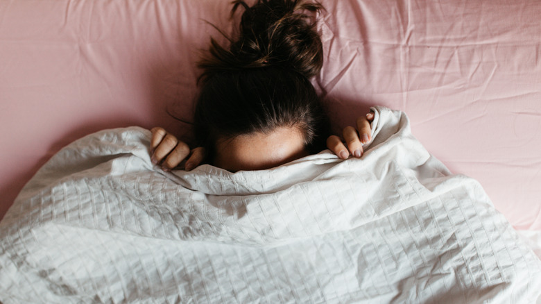 Woman hides under blanket