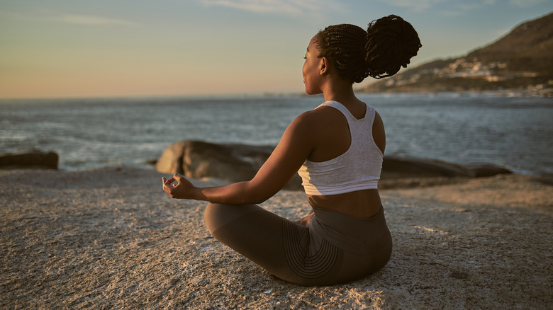 Woman meditating on the beach