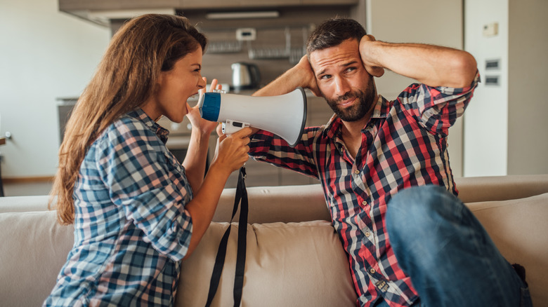 Woman yelling to man into blowhorn