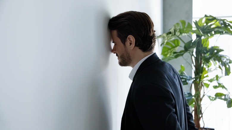 man hitting head against wall 