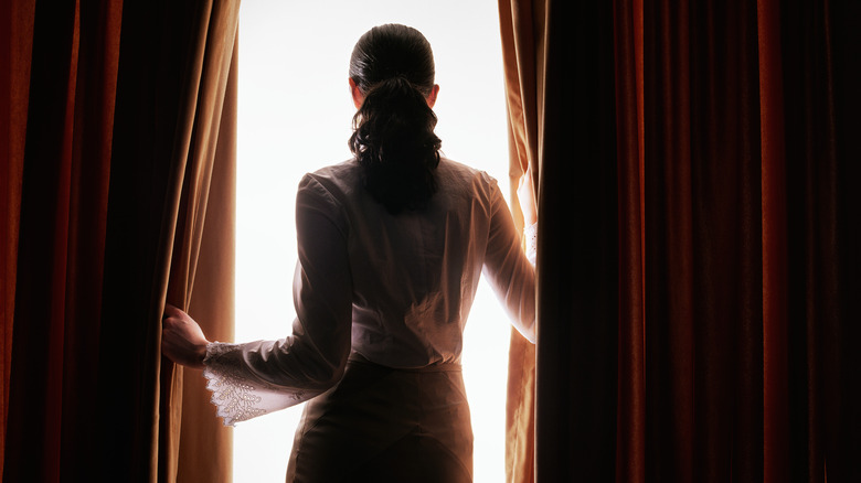 mysterious woman looking out window