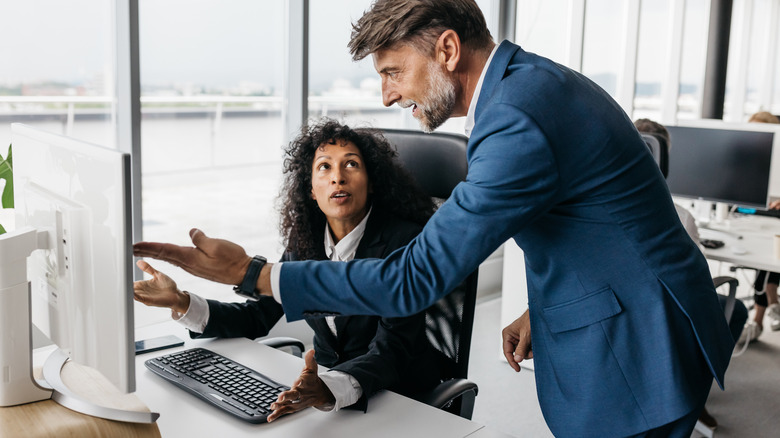 Man talking to woman at desk