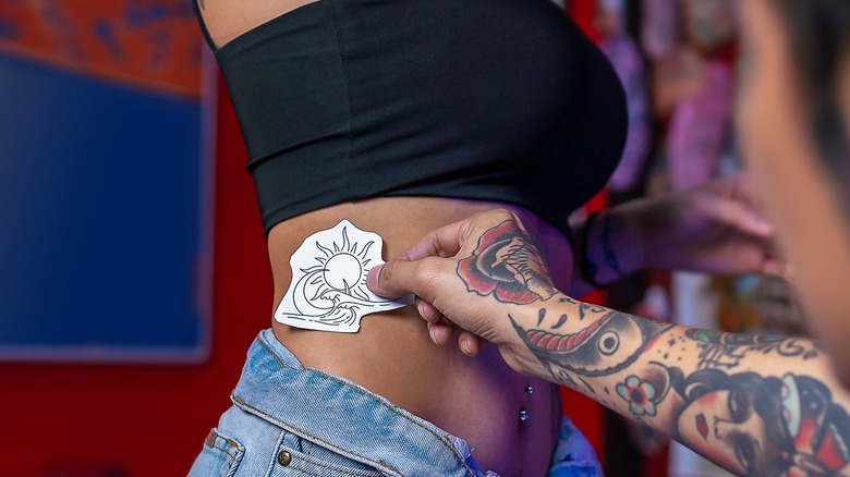 woman getting rib cage tattoo