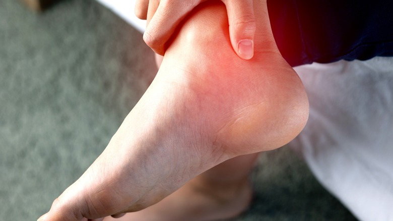 a hand holding an injured ankle