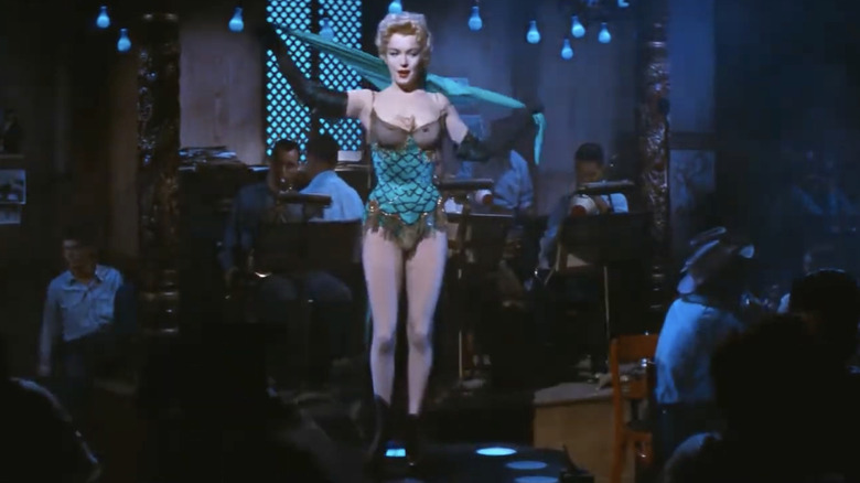 Marilyn Monroe on stage in a green and black one piece ensemble