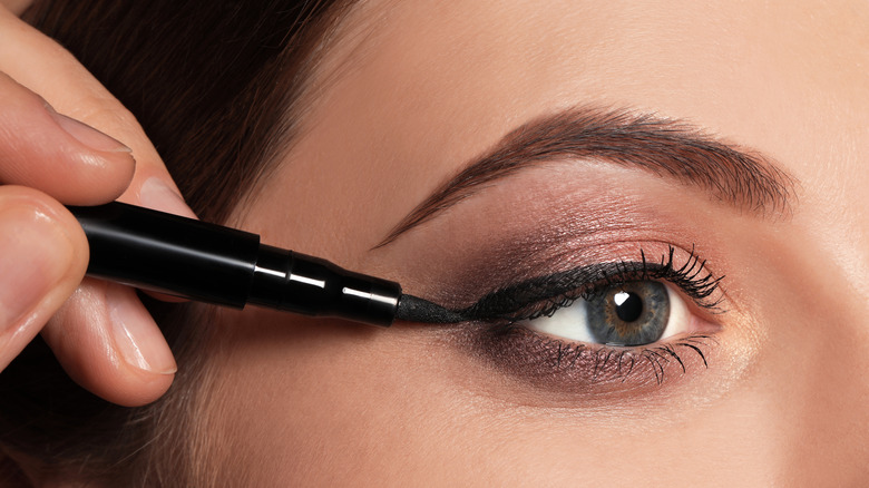 Applying eyeliner