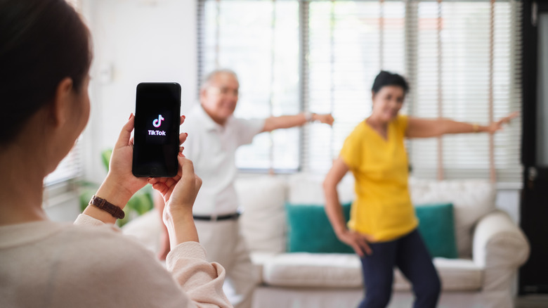 woman recording two people dancing