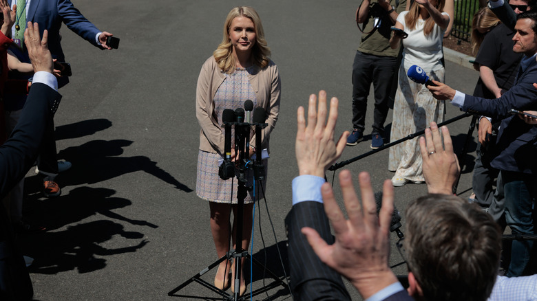 Karoline Leavitt wearing an unfashionable beige outfit while speaking to reporters on the driveway outside the West Wing