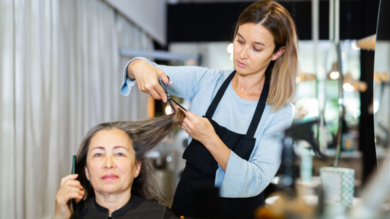 A woman with a pixie cut smiles at the camera